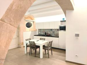 锡拉库扎Corinzia Casa Vacanze的白色的厨房配有白色的桌子和椅子