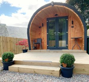 德拉姆纳德罗希特Loch Ness Woodland Pods的小木屋设有木制甲板和门