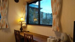 京都Guest House Nishimura - Vacation STAY 13436的配有桌子、窗户和灯的房间