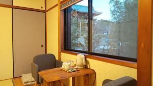 京都Guest House Nishimura - Vacation STAY 13438的客房设有桌椅和窗户。