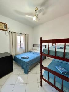 安格拉杜斯雷斯Apartamento aconchegante com ar condicionado - Frade, Angra dos Reis的一间卧室设有两张双层床和吊扇