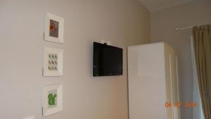 佩弗卡里Smaragdi Studios的墙上的平面电视,带有图片