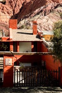 普尔马马尔卡Chilcagua的一座红色的建筑,上面有标志,上面有山