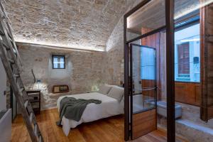 奥斯图尼Il Quinto Elemento - Residence Of Charme的一间卧室设有一张床和一间浴室。