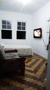 阿雷格里港Sobrado Tranquilo Centro的客厅配有床、沙发和窗户