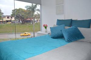佩雷拉Acogedor Apartamento, excelente ubicación. Pereira的卧室配有一张带蓝色枕头的床,卧室设有窗户