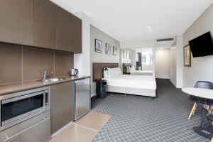 悉尼Holiday Inn & Suites Sydney Bondi Junction, an IHG Hotel的酒店客房带一张床和一个厨房