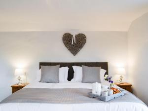 汉默Hillside Cottage的卧室配有一张壁挂着心牌的床