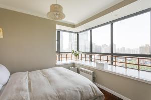 上海Xujiahui park 2BR Apt的一间卧室配有一张床,阳台配有窗户