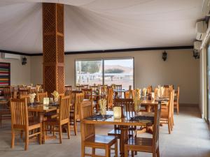 ShāhiqDesert Nights Resort的用餐室配有木桌和椅子