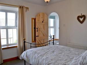 阿尼克Joellen Cottage的一间卧室配有一张床和一扇木门