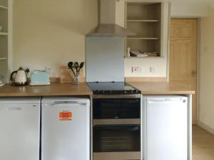 WhitekirkCauldside West Cottage的厨房配有炉灶和冰箱。