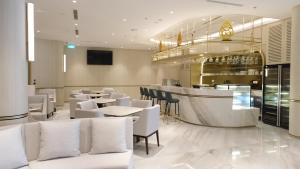 塞尔蓬加丁塞尔彭阿特里亚酒店的一间设有白色桌椅的餐厅和一间酒吧