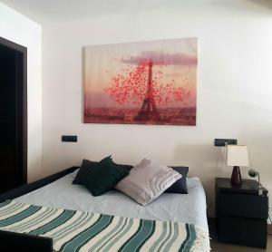 马德里DUPLEX 2 PLANTAS - c ALCALA-IFEMA-VENTAS- JARDIN & PARKING PRIVADOS- SUITES BOUTIQUE WH的一间卧室配有一张床铺,享有艾菲尔铁塔的景色