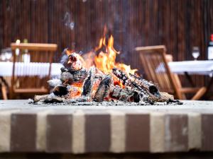 玛洛斯帕克Kruger Eden Lodge的桌子上燃着火,椅子上燃烧着火