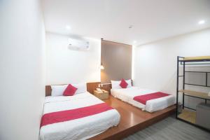 头顿Hoàng Bách Hotel的一间卧室配有两张红色和白色床单