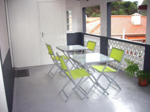 圣维森特Holidays Madeira的阳台的天井配有2张桌子和椅子