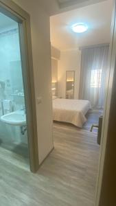 罗马卡萨特拉挪伊酒店的一间卧室配有一张床,浴室设有浴缸