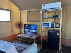 佩纳利克村Rembulan Escape - Beachfront safari tent的客厅配有沙发和带电脑的书桌