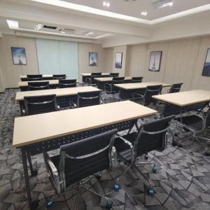 吉隆坡Hotel Aman Kuala Lumpur的一间空的教室,里面摆放着桌椅