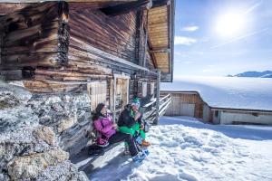 菲根Hotel Landhaus Zillertal的两个女人坐在雪房外