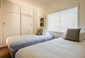 巴特曼斯贝海湾微风精品酒店的带窗户的客房内的两张床