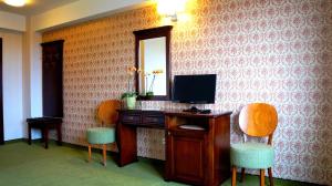 苏恰瓦雷斯登斯酒店的客房设有一张桌子、一台电视和两把椅子