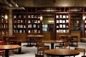 松本Matsumoto Jujo的一间带木桌、椅子和书架的餐厅
