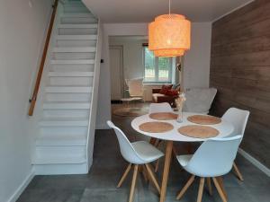 赫拉尔兹贝亨Huisje op de Muur van Geraardsbergen的一间配备有白色桌椅的用餐室