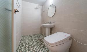 泗川Owl Hotel的一间带卫生间、水槽和镜子的浴室