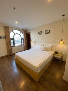 河内Khách Sạn A83Hotel的卧室配有一张大白色床和窗户