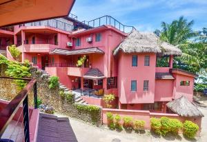 长滩岛Signature Boracay Punta Rosa formerly Punta Rosa Boutique Hotel的一座大型粉红色建筑,屋顶