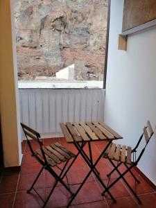 圣地亚哥海滩Casa Alisios的一张木桌和两把椅子靠窗