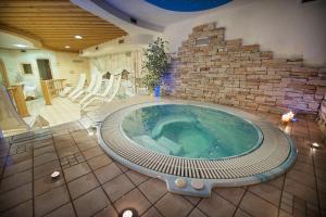 利维尼奥Hotel Valtellina的砖墙房间内的热水浴缸