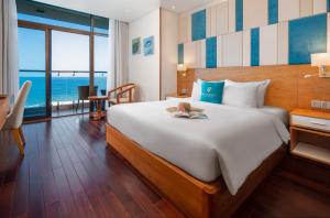 岘港岘港曼迪拉海滩酒店的一间卧室设有一张大床,享有海景