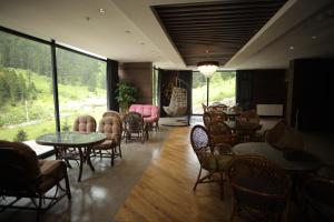 特拉布宗PAZARCIK MOUNTAIN HOTEL的餐厅设有桌椅和大窗户。