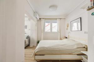 塞萨洛尼基Lovely small (parterre) apartment in Thessaloniki的白色的卧室设有床和窗户