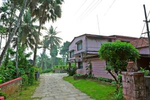 奇克马格尔GiriDarshini Homestay - Pool, Falls, 3BH, Home Food & Estate的房子旁的房屋和人行道