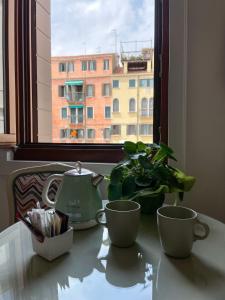 威尼斯Residenza San Silvestro的桌子,有2杯茶壶和1个窗口