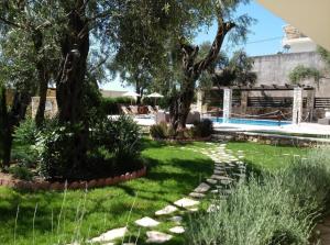 帕尔加Vassilis Guest House的一座种植了树木的花园和一个游泳池