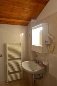 坎波多尔奇诺Campodolcino Camping的一间带水槽和镜子的浴室以及窗户。