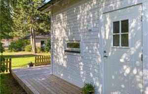 GnisvärdBeautiful Home In Gotlands Tofta With Kitchen的白色的房子,有门和甲板