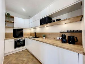 克雷翁AppartChic - appartement standing - plein Centre & Parking privé的厨房配有白色橱柜和黑色家电
