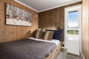 LonaLibehi的一间卧室配有一张带木墙和窗户的床。