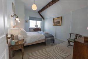 勒德洛Pass the Keys Magical period house in the heart of Ludlow的一间卧室配有一张床和一张带台灯的桌子