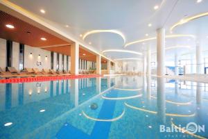 科沃布热格Apartamenty BalticON Polanki Aqua的一座带椅子和天花板的酒店游泳池