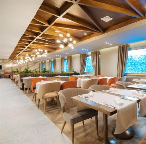 亚霍里纳Hotel Rajska dolina Jahorina的用餐室设有桌椅和窗户。
