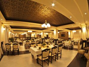 萨图马雷旋律酒店的一间设有白色桌椅的用餐室