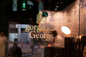 开普敦Gorgeous George by Design Hotels ™的存储窗口中一个人的反射