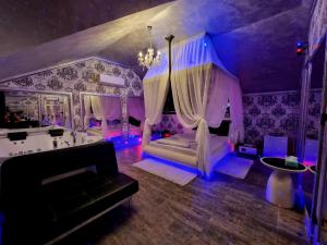 布拉索夫Anadi Hotel Boutique的紫色的客房配有一张床和一张沙发